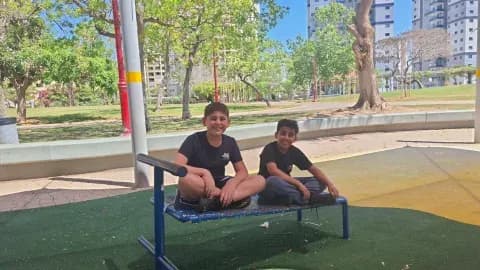 שני תלמידים יושבים על ספסל בחצר