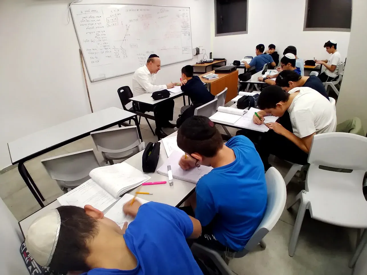 תלמידים לומדים בשולחנות הכיתה