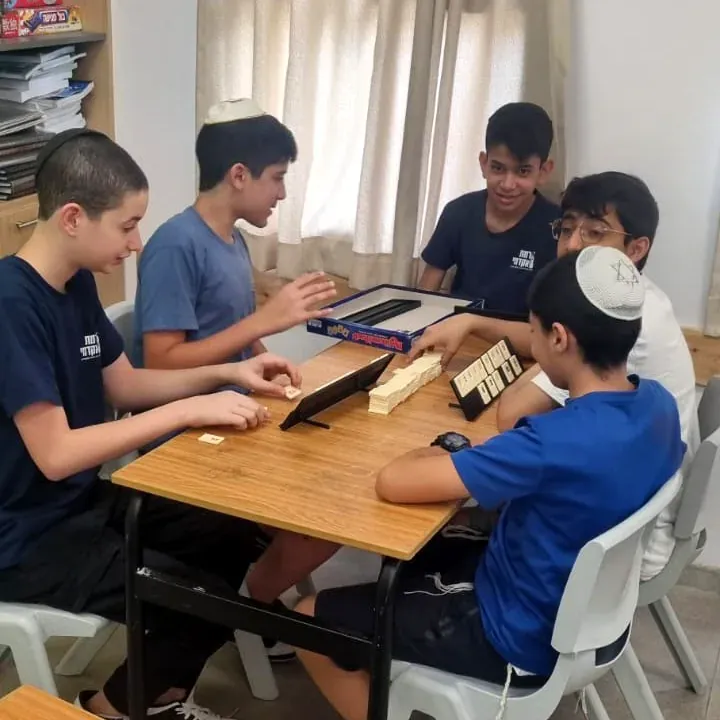 תלמידים סביב שולחן במשחק קבוצתי