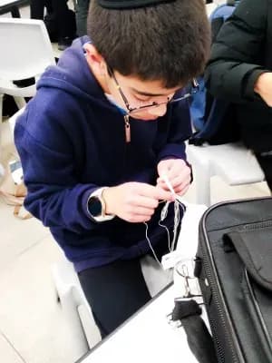 תלמיד קושר ציציות